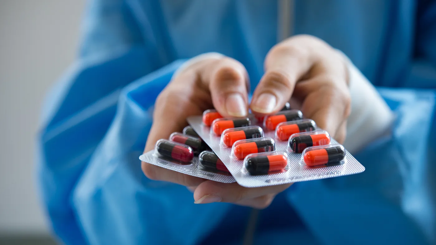 Hands holding blister packs of medication